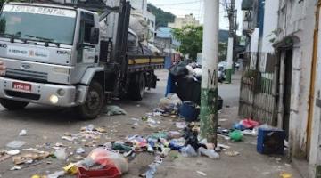caminhão está parado em rua. Há muito lixo no chão em torno do imóvel. #paratodosverem