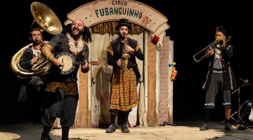 atores tocam instrumentos musicais em cena de o circo fubanguinho #pracegover 