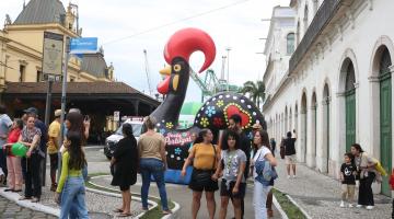 grande galo português ao fundo com turistas em torno. #paratodosverem