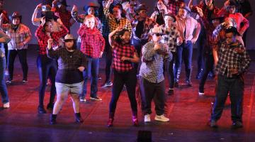 alunos dançando no palco #paratodosverem