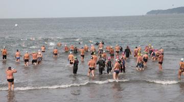Nadadores entram no mar da Ponta da Praia. #paratodosverem