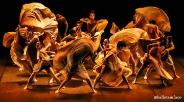 bailarinos dança em palco. Eles movimentam suas saias com velocidade. #paratodosverem 