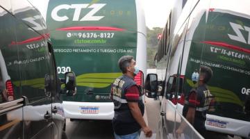 ÔNibus estão parados e fiscal de turismo se aproxima. #Paratodosverem