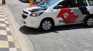 viatura da polícia em rua. Homens estão em pé atrás. #paratodosverem