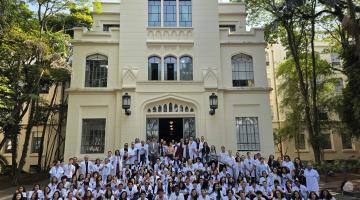 alunos na frente da faculdade de branco #paratodosverem 