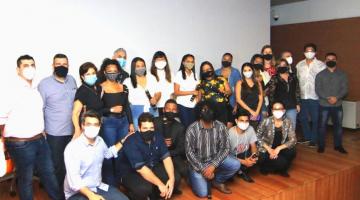 A equipe de formandos reunida em palco posa para foto. #paratodosverem