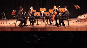 grupo toca música clássica no palco #pracegover 