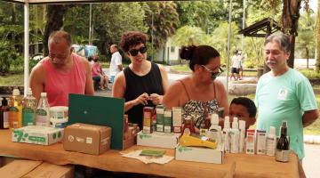 pessoas estão escolhendo produtos em barraca #pracegover 