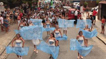 Crianças desfilam pela rua com fantasias. #paratodosverem