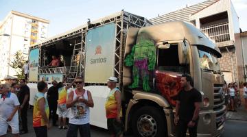 Carro de som na rua com alguns foliões ao lado. #Paratodosverem