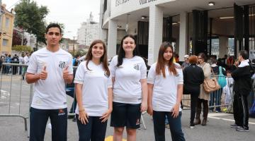 quatro alunos com camisas do santos posam na porta do estádio #pracegover