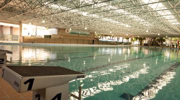 Piscina olimpica cheia d'água. Em primeiro plano os locais para salto dos atletas. #Pracegover