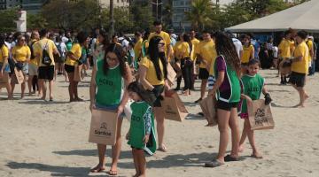 pessoas recolhendo lixo em praia #paratodosverem