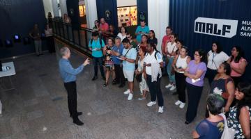 grupo de pessoas assiste homem falando dentro de museu. #paratodosverem 