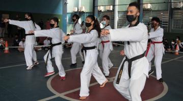 pessoas com uniforme de caratê fazendo exercícios #paratodosverem