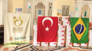 Caixas de cestas básicas com a bandeira da Turquia e do Brasil em cima. #paratodosverem