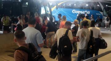 pessoas fazem fila para entrar em ônibus encostadas nas baias da rodoviária. #paratodosverem 