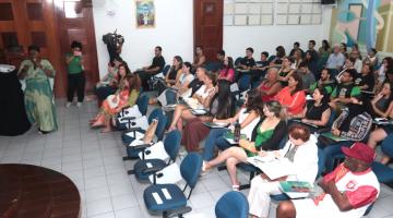 uma pessoa em pé de frente para uma plateia #paratodosverem