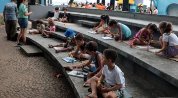 crianças fazem desenhos em área externa do aquário. #paratodosverem