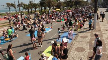 crianças e adultos brincam na avenida da praia. #paratodosverem 