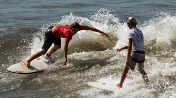 Dois surfistas dividem a mesma onda #pracegover 