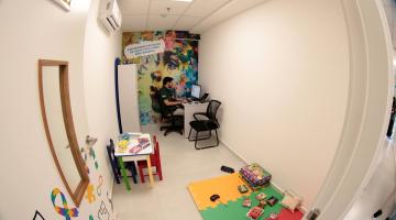 sala com tapete infantil, jogos e armários. #paratodosverem 