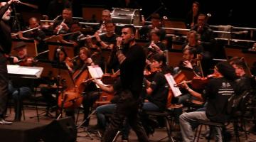 Cantor e orquestra ao fundo #paratodosverem