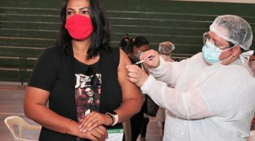 Mulher recebe aplicação na vacina de enfermeiro. #paratodosverem