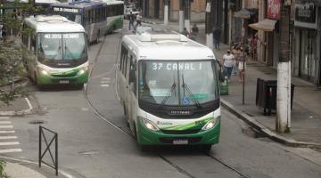 rua com quatro ônibus transitando. #paratodosverem