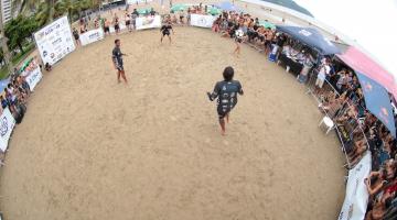 arena na faixa de ariea com grupo de quatro pessoas lançando a bola uma para a outra. #paratodosverem 