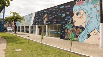 edificação com muro pintado , à frente grama #paratodosverem