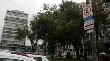 placa de zona azul em posto. há carros na rua. Ao fundo se vê árvores e prédios. #paratodosverem 