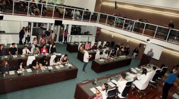 jovens estão sentados no plenário da Câmara municipal. #paratodosverem