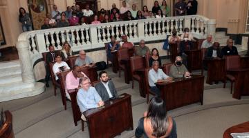 auditório com varias pessoas sentadas ouvindo palestra #paratodosverem