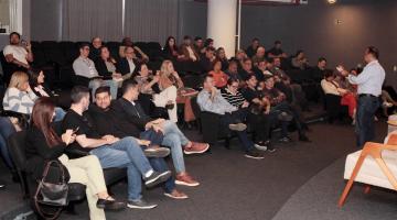 Pessoas no auditório acompanhando o evento #paratodosverem 