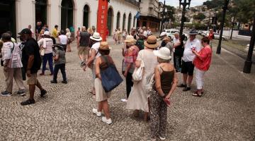 turistas estão na frente de museu pelé. #paratodosverem