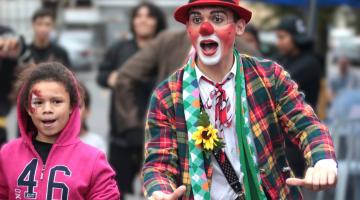palhaço ao lado de criança  em feira livre. #paratodosverem