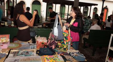 pessoas comprando em feira de economia criativa #paratodosverem 