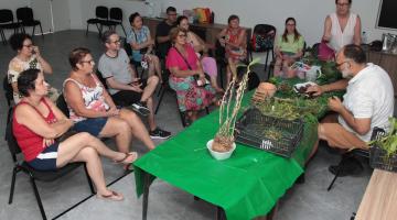 pessoas acompanhando aula com plantas à mesa #paratodosverem 