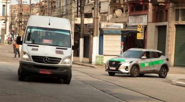 van de lotação e táxi na rua. #paratodosverem