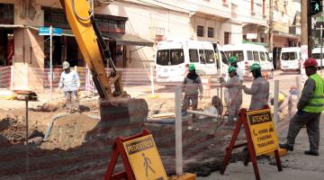 rua interditada e com obras. Há máquinas operando e homens trabalhando na pista. #paratodosverem 