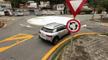 placas em primeiro plano e carro entrando na rotatória ao fundo #paratodosverem