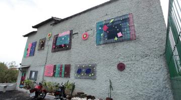 janelas de prédio decoradas com crochê. #paratodosverem