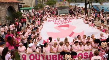 multidão caminha de rosa com faixa do outubro rosa #pracegover 