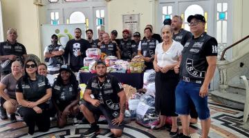 integrantes de grupo posam com produtos #paratodosverem