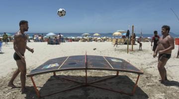 Jogadores na praia praticam  o esporte #paratodosverem