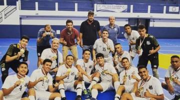 Jogadores de futsal com medalhas sentados na quadra #paratodosverem