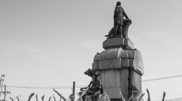 bailarinas em frente a uma estátua #paratodosverem