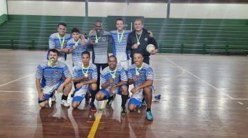 equipe vencedora posa para foto, cada um como a sua respectiva medalha. São 9 pessoas na foto