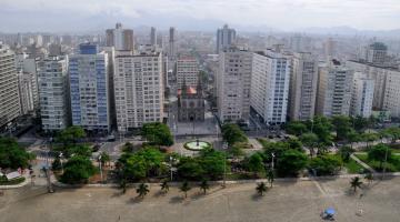 vista geral do bairro, a partir da praia, com muitos prédios ao fundo e a igreja ao centro. #paratodosverem